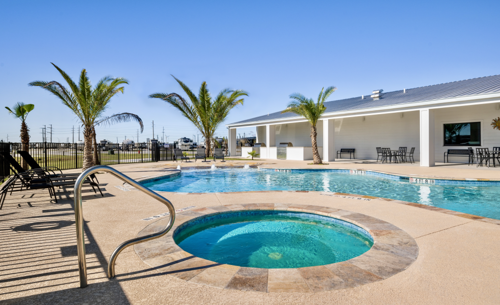 a pool with a hot tub and a building with palm trees